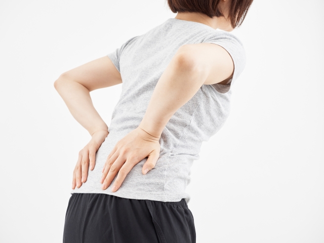 腰痛で腰にて当てる女性